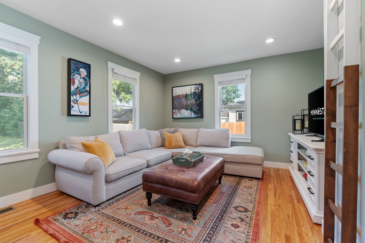 Sink into this plush sectional where sage walls and warm wood floors create your perfect retreat for movie nights.