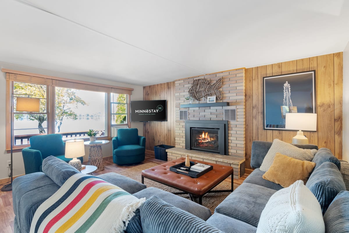 Cozy up in your stylish living room where warm wood accents and a crackling fireplace create the perfect mountain retreat atmosphere.