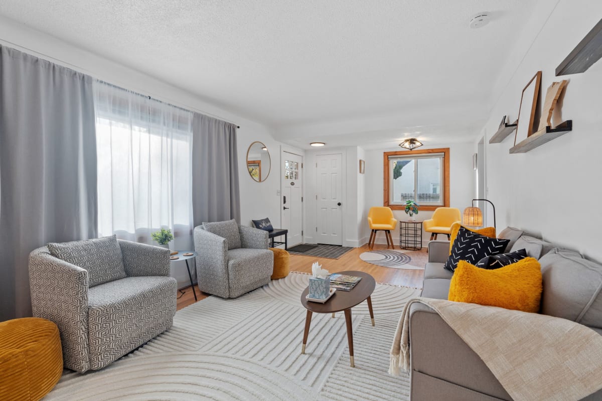 Settle into this bright, stylish living space where vibrant orange accents and geometric patterns create a warm, welcoming atmosphere for your stay.