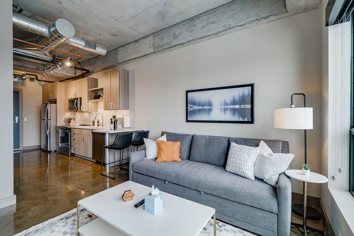 Relax in your chic loft with exposed concrete ceilings, modern kitchen, and comfortable seating area perfect for unwinding after city adventures.