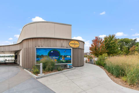 Modern building exterior with a mural and colorful trees.