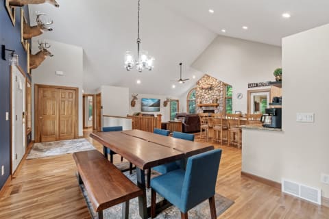 Interior of a lake house with wooden furniture, deer head decor, and a fireplace.