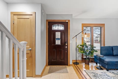 Interior view of a home entryway with a dark front door and a blue couch.