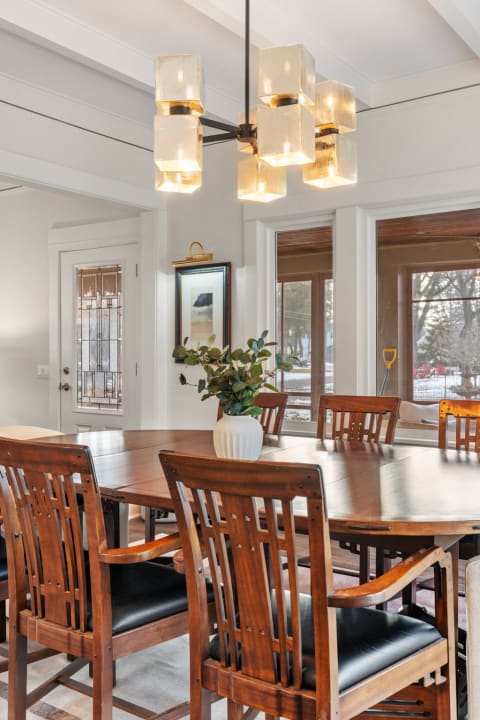 A cozy dining room with a wooden table and stylish pendant light, inviting for meals and conversations.
