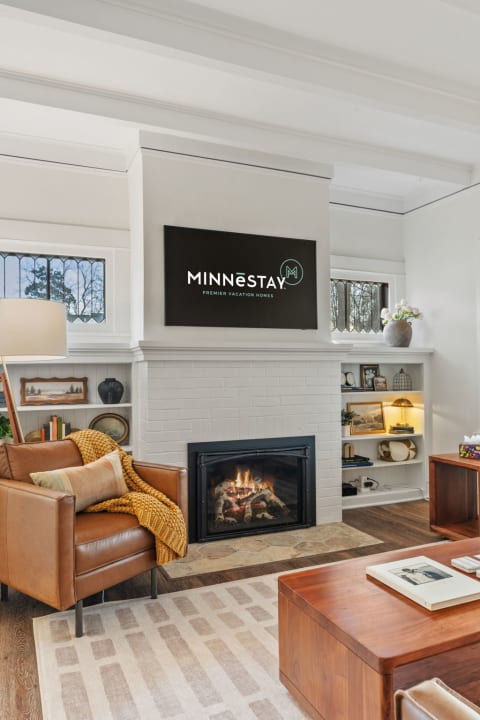 A cozy living room with a brown leather chair, a fireplace, and built-in shelves with decorative items.