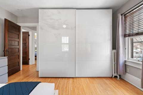 Interior view of a modern bedroom with a white closet and wooden elements.