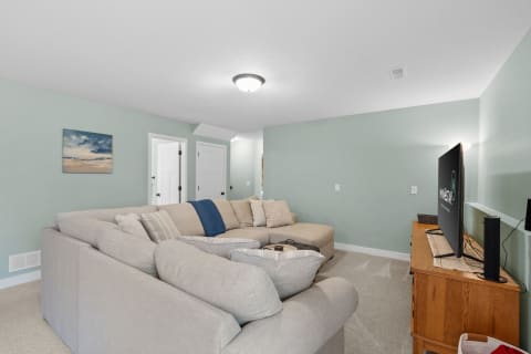 Cozy living room featuring a light mint green wall and a large beige sectional sofa.