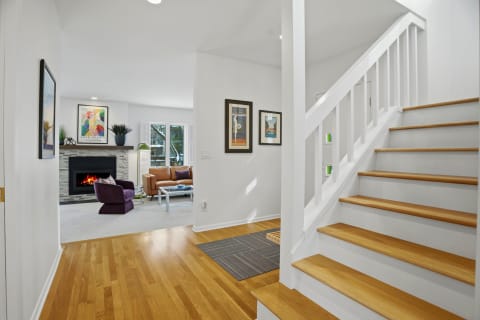 Interior view of a cozy living space with a staircase, fireplace, and inviting furniture.