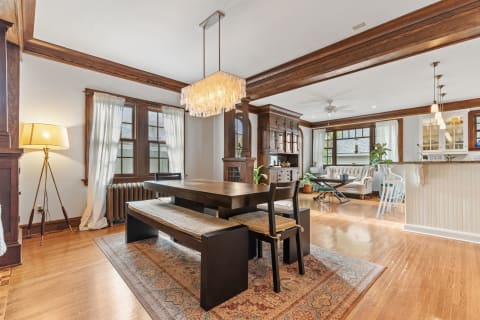 A well-decorated dining room with a wooden table, comfortable seating, and a stylish chandelier