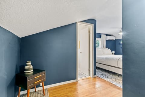 Cozy bedroom corner with blue walls and a nightstand.