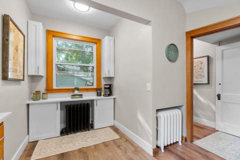 Cozy entryway with white cabinetry, a window, and a decorative rug.