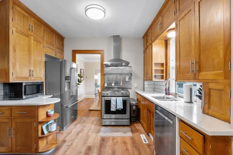 Modern kitchen featuring stainless steel appliances and light wood cabinets.