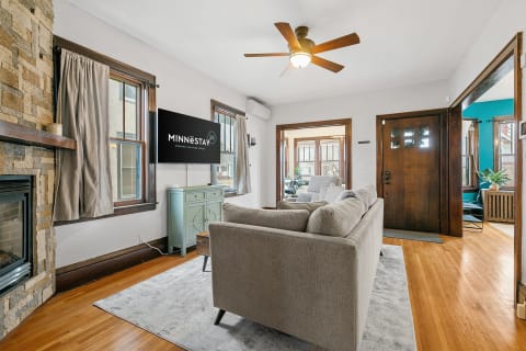Cozy living room with gray sofa, stone fireplace, and light blue sideboard.