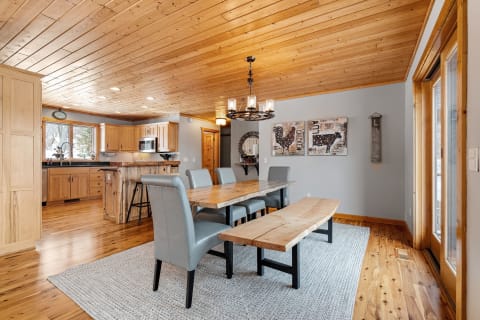 Dining area with wooden ceiling, table, and gray chairs.