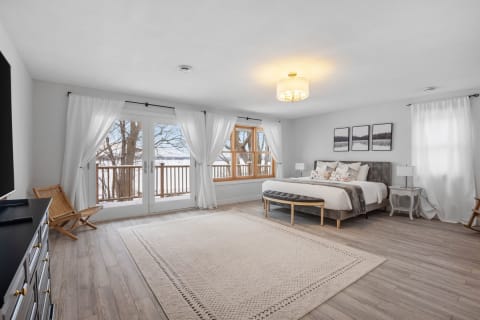 Bright and tranquil bedroom with large windows and lake view.