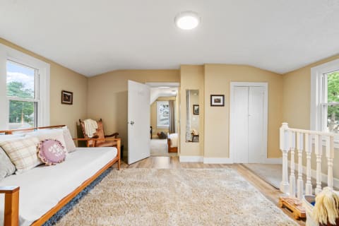 Cozy room with a daybed, rocking chair, and soft natural lighting.
