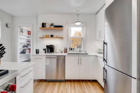 Modern kitchen with white cabinets and open shelving.