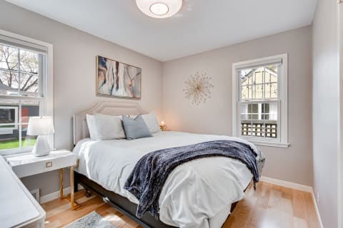 A beautifully designed bedroom featuring a bed, nightstand, and modern decor.