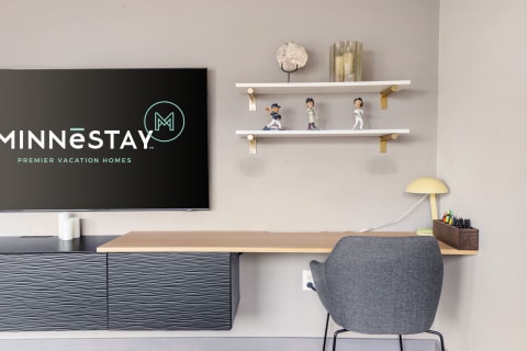 Modern workspace with desk, decorative shelf, and MINNESTAY logo.
