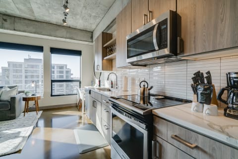 Stylish modern kitchen with stainless steel appliances and a cozy sitting area.