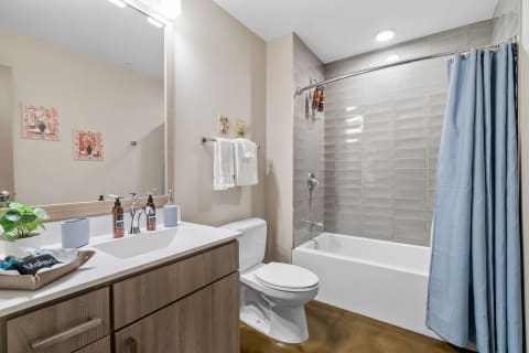 Modern bathroom featuring a white sink, beige walls, and decorative elements.