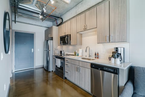 A contemporary kitchen featuring stainless steel appliances and light wood cabinets.