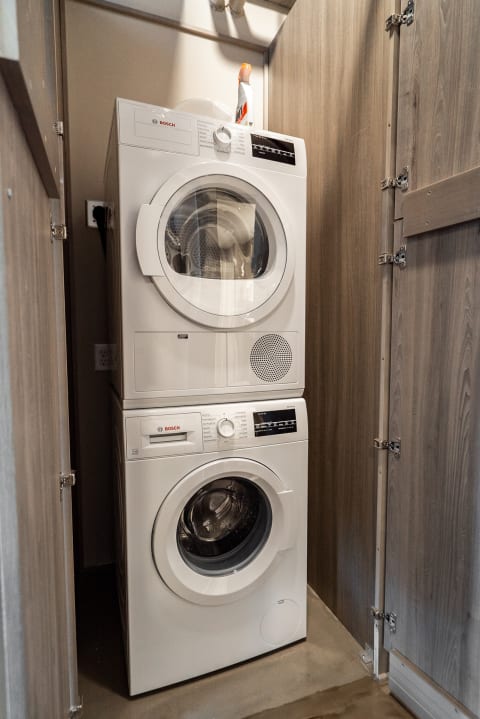 Stacked Bosch washer and dryer in a small laundry closet.