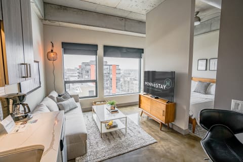 Modern studio apartment with a cozy living space and urban views.