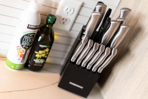 A kitchen countertop displaying a knife block, cooking spray, and olive oil.