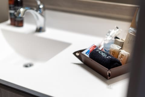 Contemporary bathroom countertop with leather organizer and chrome faucet.