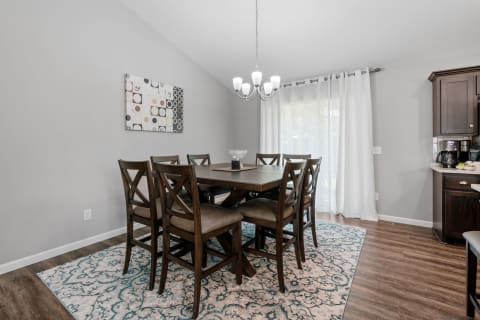 A stylish dining room with a wooden table, comfortable chairs, and decorative elements.