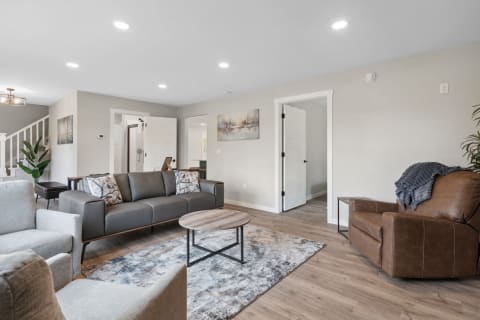Contemporary living room with gray sofa, brown leather armchair, and stylish decor.