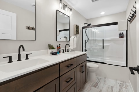 Modern bathroom with sleek fixtures, minimalist design, and a glass shower enclosure.