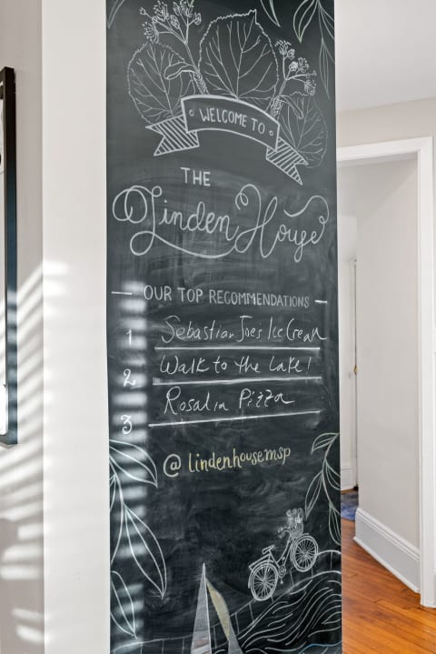 Chalkboard wall with welcoming messages and top recommendations at The Linden House.