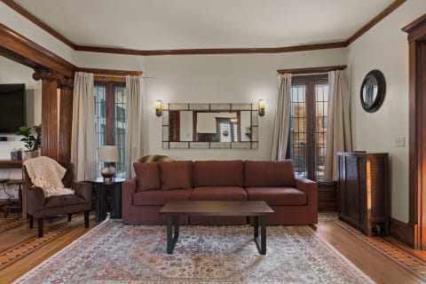 Cozy living room featuring a brown sofa, wooden coffee table, and warm lighting with rich wood trim.
