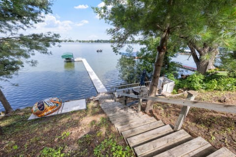 Wooden stairs leading down to a calm lake with boats in the distance.