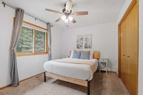Cozy bedroom with a queen-size bed and window view.