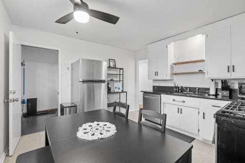 Interior view of a modern kitchen featuring black dining table and stainless steel appliances.