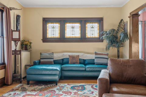 Cozy living room with teal sectional couch and stained-glass windows.