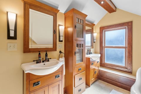 A beautifully designed bathroom featuring wooden cabinetry, dual sinks, and soft lighting.