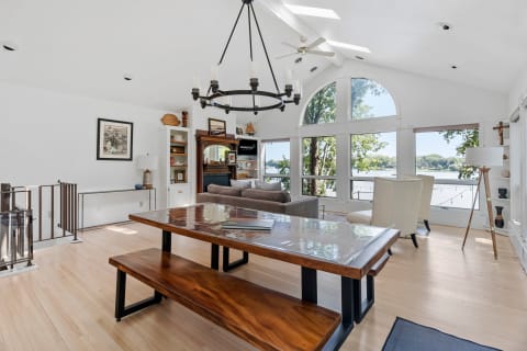 Interior of a cozy living room featuring large windows that overlook a lake, complemented by stylish furniture.