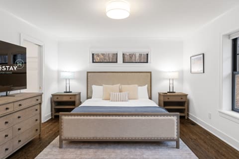 Modern bedroom featuring a king bed, warm lighting, and stylish decor.