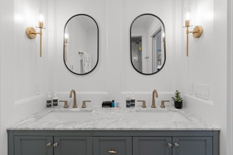 Modern bathroom sink area featuring dual sinks and marble countertop.