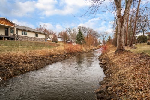 A peaceful creek meanders through the residential neighborhood, creating a tranquil natural setting near the property.