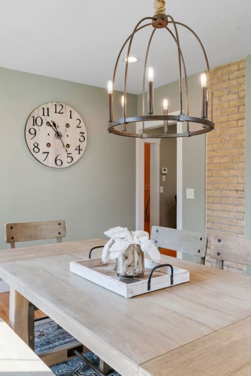 Gather around your rustic dining table beneath warm chandelier light, where country charm meets modern comfort for memorable meals.