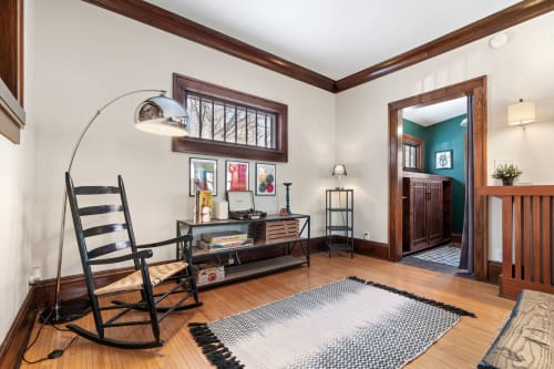 Unwind in your charming reading nook with rich wood details and a comfy rocking chair—perfect for quiet moments.