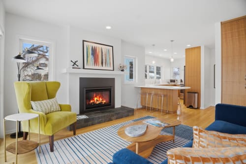 Relax by your cozy fireplace in this bright, modern family room where stylish furniture and warm wood tones create the perfect retreat.