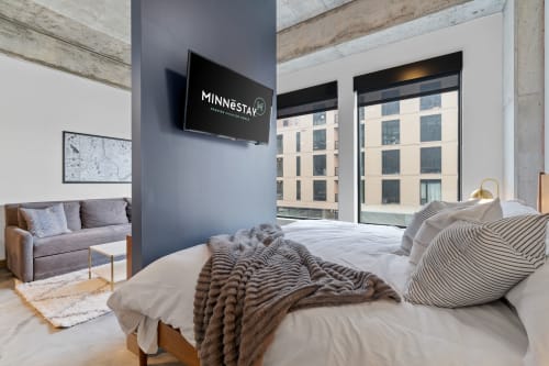 Unwind in your stylish bedroom with exposed beams, plush bedding, and city views from your private window.
