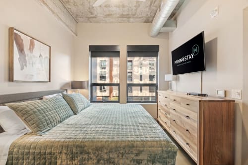 Sink into your plush bed while city views frame your stay through expansive windows in this stylish urban retreat.