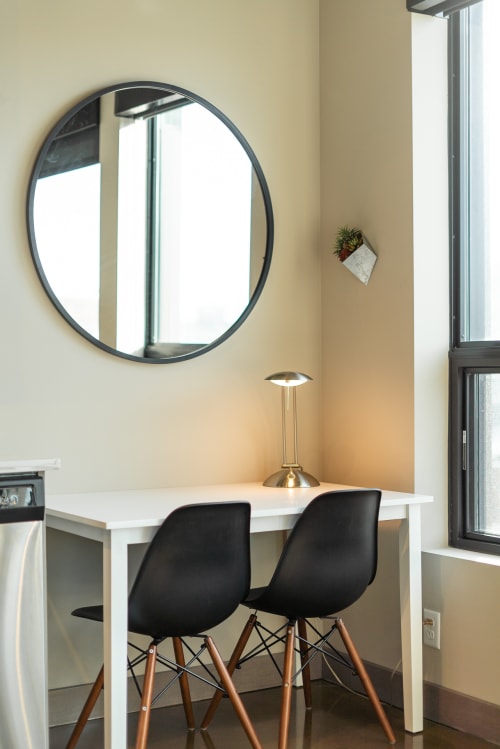 Your stylish workspace awaits with modern chairs and warm lighting by the window.